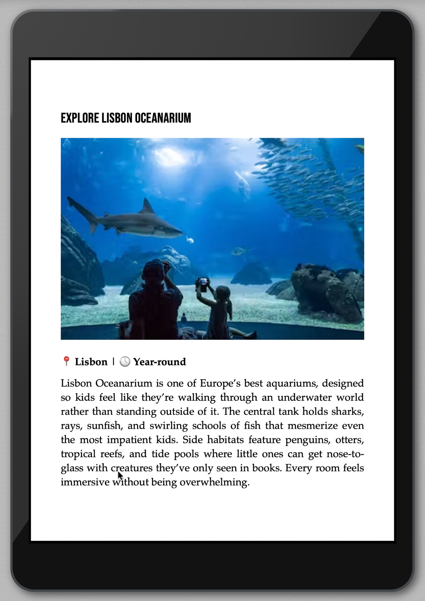 iPad displaying an article about Lisbon Oceanarium with an image of a shark and people underwater.